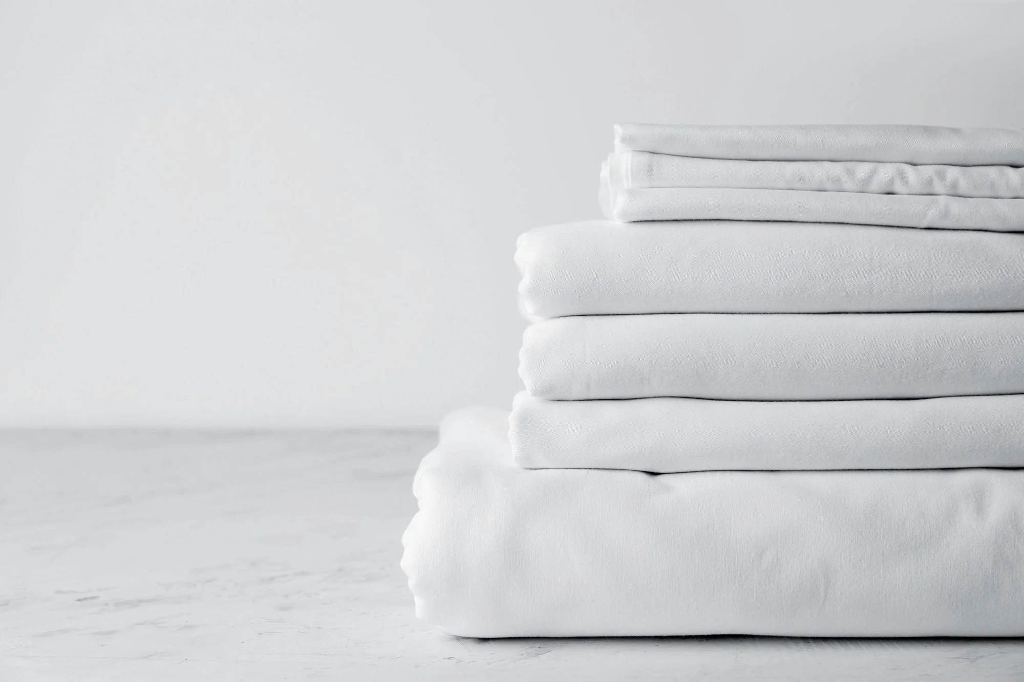Stack of folded white bed linens